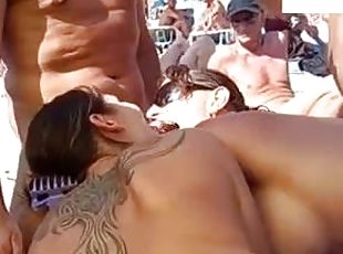 Two girls suck a cock on a beach and get cum on their tits