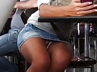 Girl wearing a miniskirt flashes her pussy in a cafe