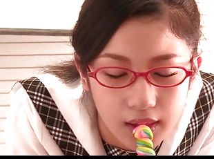 Schoolgirl in glasses licks a lollipop