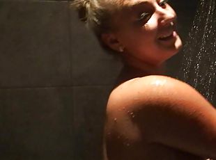 A chubby blonde with monster tits takes a hot shower