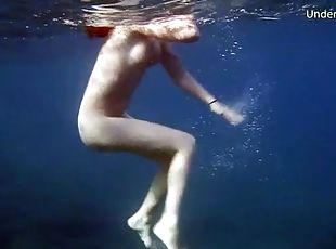 Naked redheaded beauty swims in the ocean